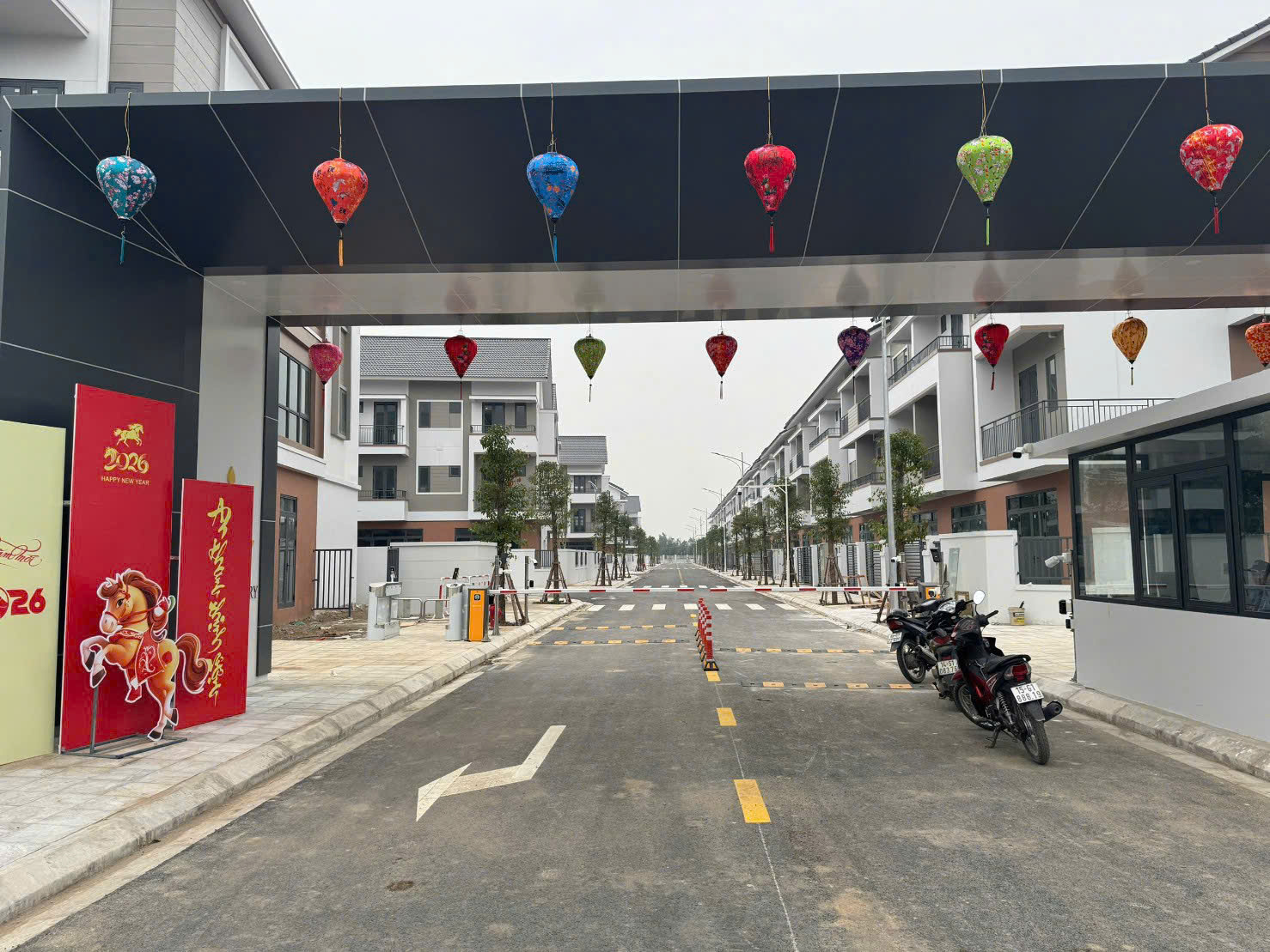Cổng vào khu nhà phố mới xây trang trí đèn lồng nhiều màu và biển chúc mừng năm mới 2026